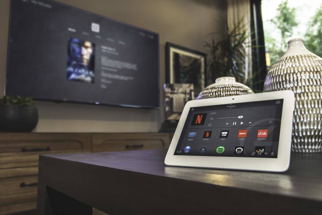 Touchscreen home control beside a television in a living room